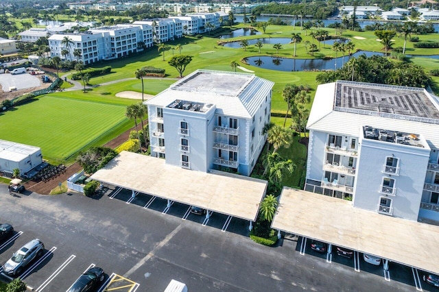 drone / aerial view with a water view and golf course view