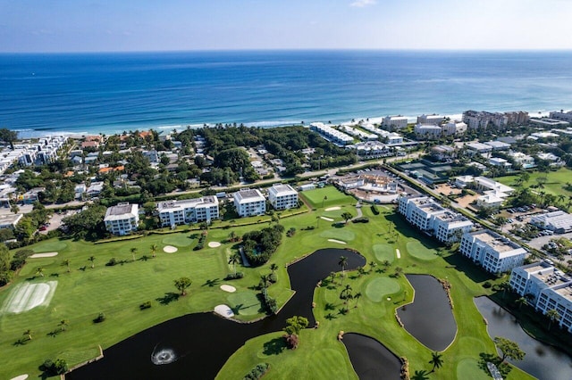 drone / aerial view with a water view, a city view, and golf course view