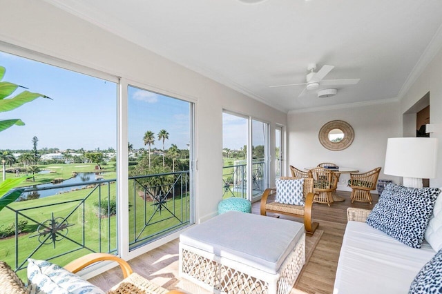 sunroom / solarium featuring a ceiling fan and a water view