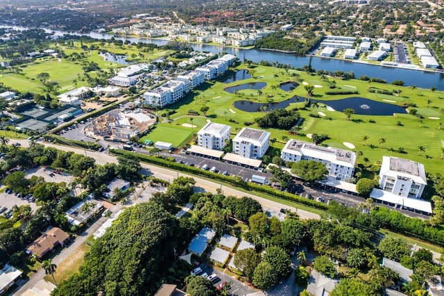 drone / aerial view with view of golf course and a water view