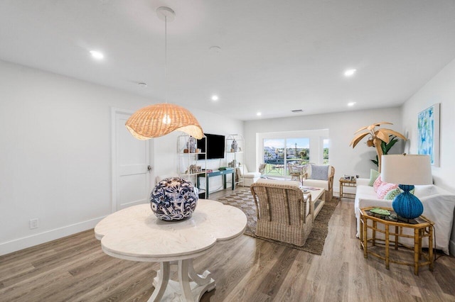 living area featuring baseboards, wood finished floors, and recessed lighting