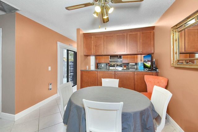 kitchen with light tile patterned flooring, a textured ceiling, and dark stone countertops