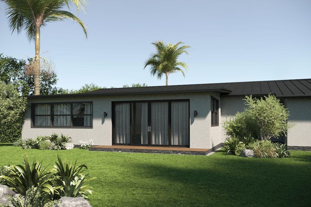 219 32nd St, West Palm Beach, FL 33407 - back of property featuring stucco siding, a yard, and a standing seam roof