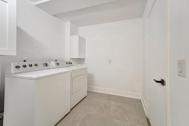 washroom with cabinets and washer and dryer