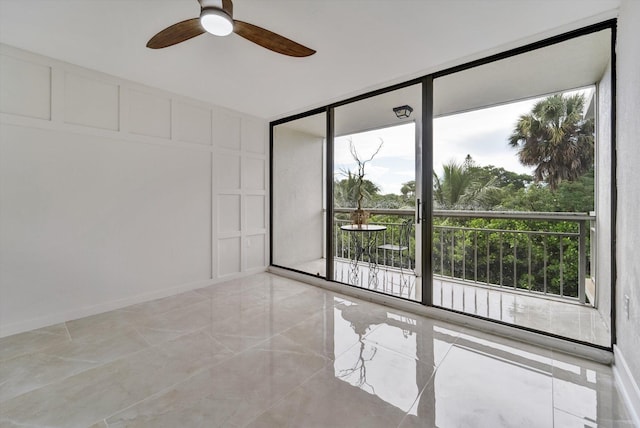 spare room featuring ceiling fan and floor to ceiling windows