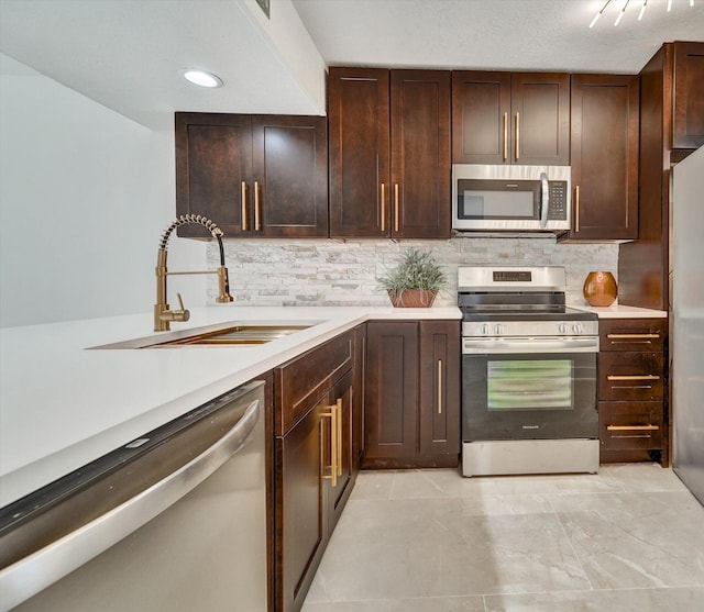 kitchen with stainless steel appliances, tasteful backsplash, dark brown cabinets, and sink