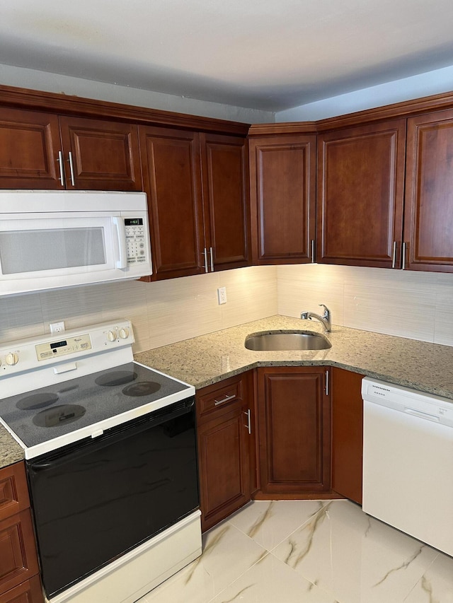 kitchen with marble finish floor, a sink, backsplash, white appliances, and light stone countertops