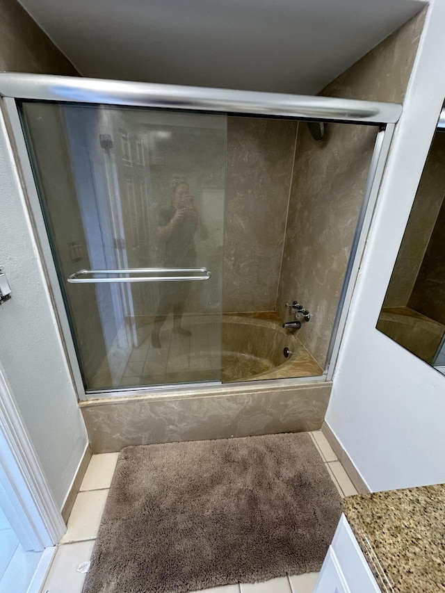 bathroom featuring combined bath / shower with glass door and tile patterned flooring