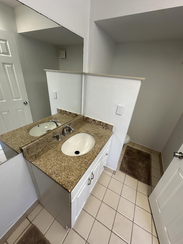 bathroom featuring tile patterned flooring, toilet, vanity, and baseboards