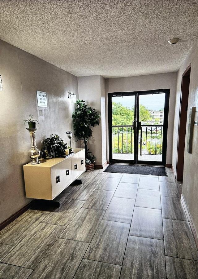 doorway featuring baseboards and a textured ceiling