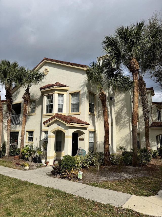 mediterranean / spanish house with a tiled roof and stucco siding