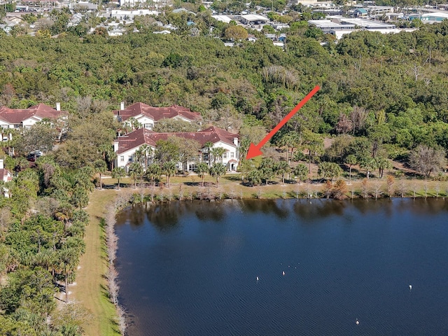 birds eye view of property with a water view and a wooded view