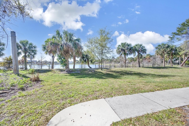 view of community featuring a lawn and a water view