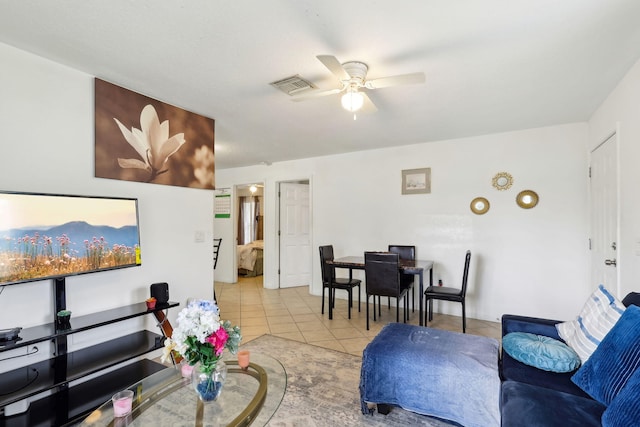 living area with tile patterned flooring, visible vents, and a ceiling fan