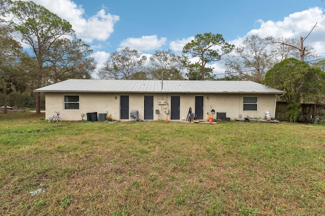 view of front facade with metal roof, a front lawn, and stucco siding