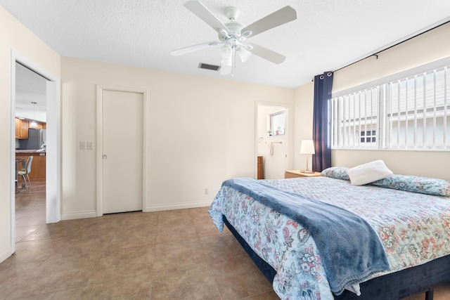 tiled bedroom with a textured ceiling, a ceiling fan, visible vents, and baseboards