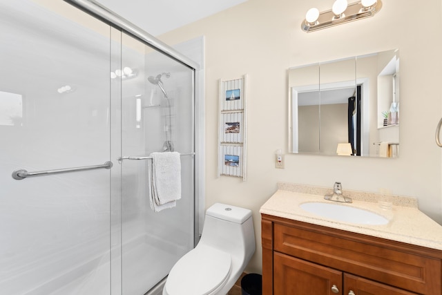 bathroom featuring toilet, a shower stall, and vanity