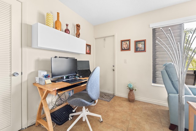 office area featuring a healthy amount of sunlight, light tile patterned floors, and baseboards