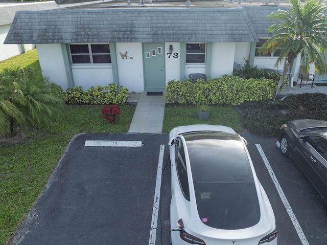 exterior space with uncovered parking and stucco siding