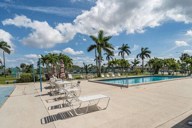 pool with a patio and fence