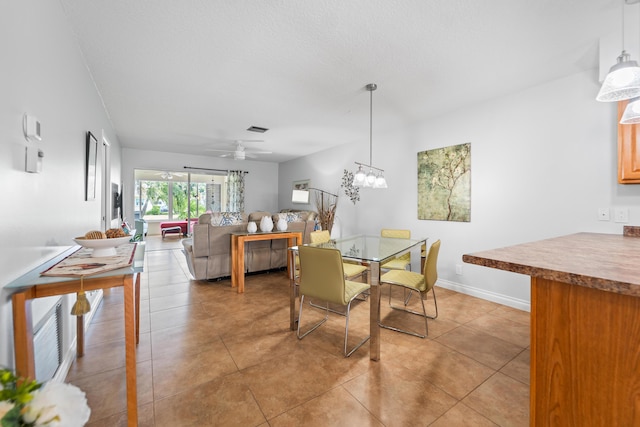 dining room featuring light tile patterned floors, baseboards, visible vents, and ceiling fan with notable chandelier