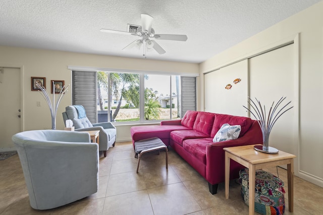 living room featuring ceiling fan, a textured ceiling, and light tile patterned flooring