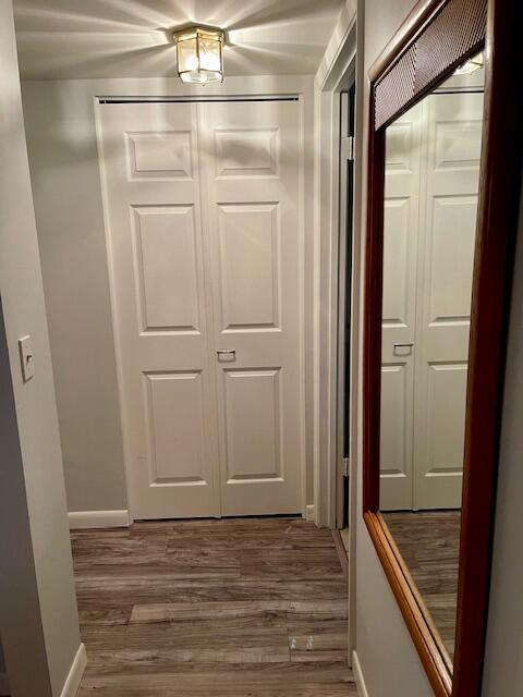 hall with baseboards and wood finished floors