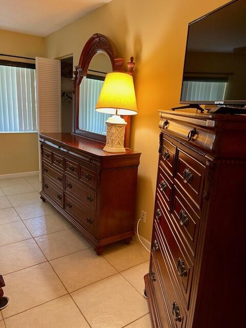 bedroom with light tile patterned floors and baseboards