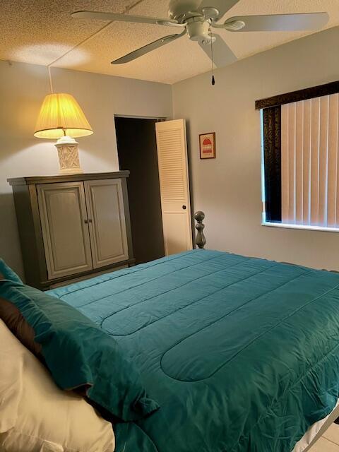 bedroom with a textured ceiling and a ceiling fan