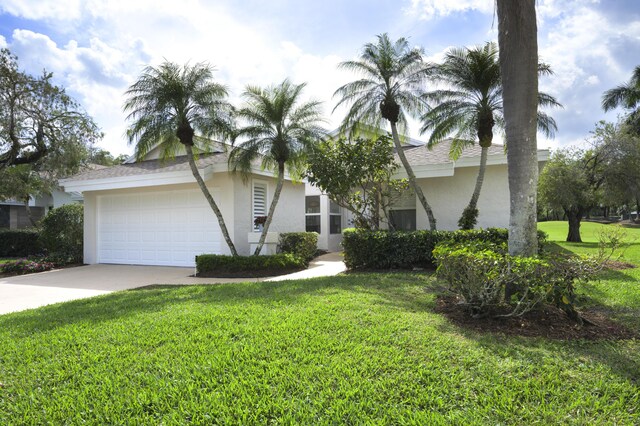 view of front of home featuring a garage, concrete driveway, roof with shingles, a front lawn, and stucco siding