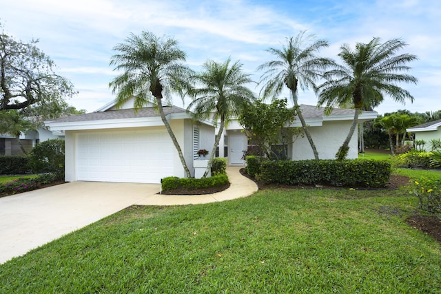 view of front of home with a garage, concrete driveway, a front lawn, and stucco siding