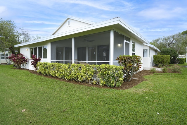 view of side of home featuring a sunroom, stucco siding, and a yard