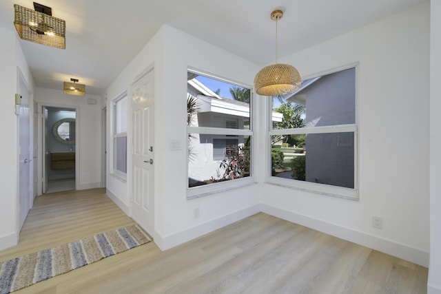 unfurnished dining area featuring light wood-style flooring and baseboards