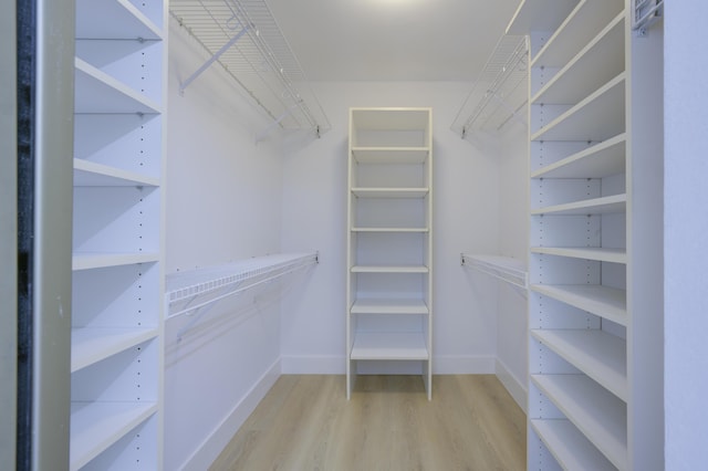 walk in closet with wood finished floors