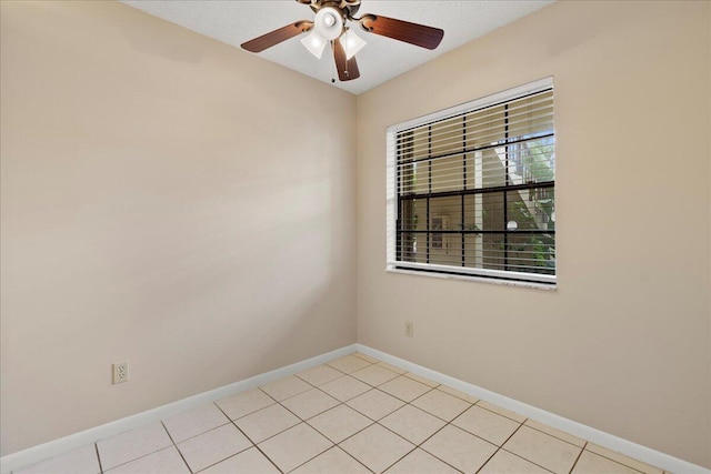 unfurnished room with a ceiling fan, light tile patterned flooring, and baseboards