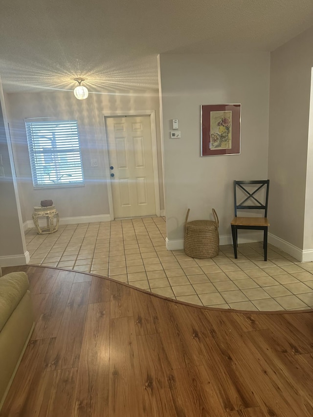 entrance foyer with a textured ceiling and light hardwood / wood-style floors