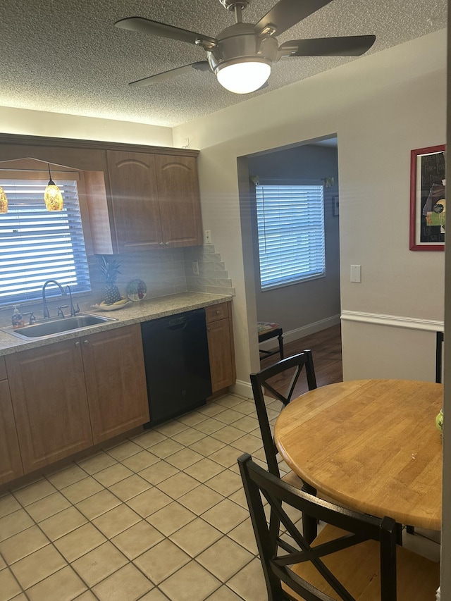 kitchen featuring sink, dishwasher, ceiling fan, a textured ceiling, and decorative backsplash