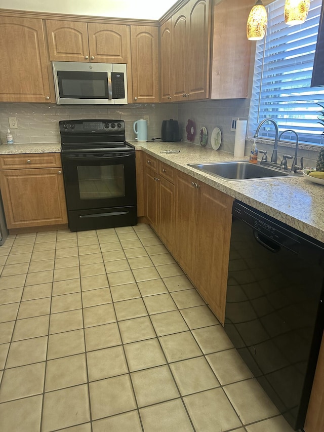 kitchen featuring pendant lighting, sink, decorative backsplash, light tile patterned floors, and black appliances