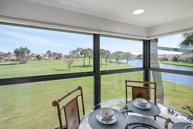 sunroom featuring a water view