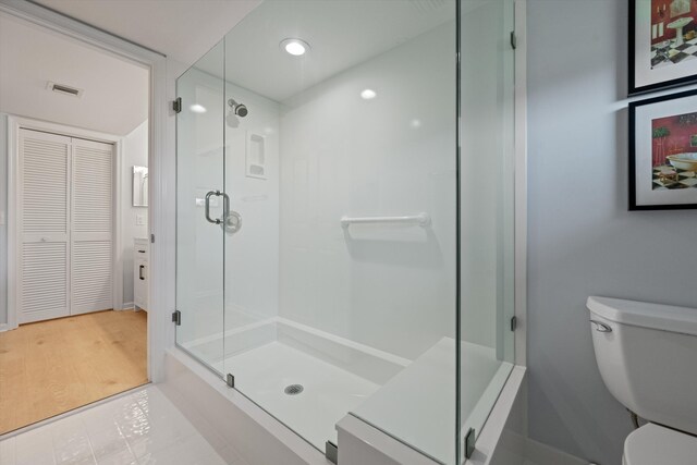 bathroom with toilet, a closet, visible vents, and a stall shower