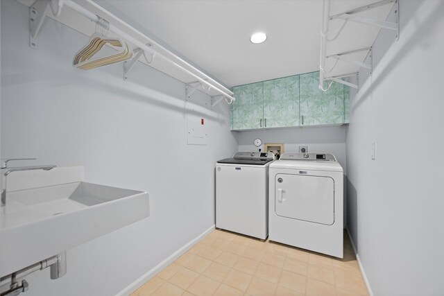 clothes washing area featuring laundry area, washer and clothes dryer, a sink, and baseboards