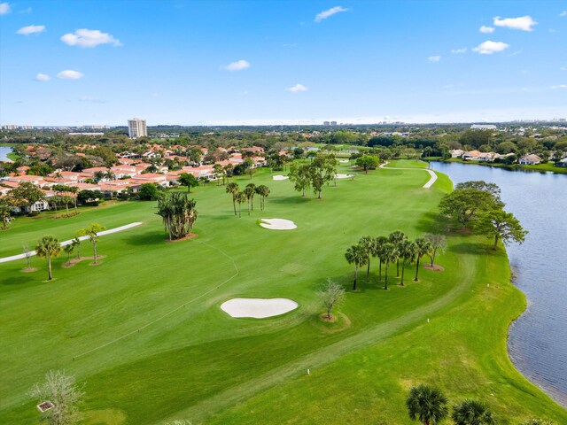 birds eye view of property with golf course view and a water view