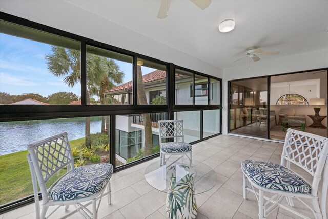 sunroom featuring a water view and ceiling fan