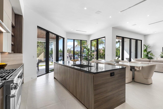 kitchen featuring open floor plan, a kitchen island with sink, a sink, and modern cabinets