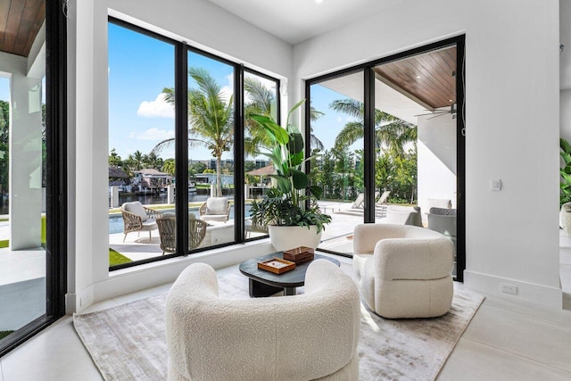 doorway to outside with a water view and baseboards