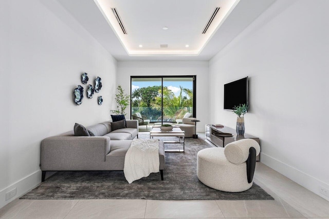 living area featuring baseboards, visible vents, and a raised ceiling