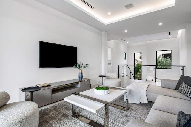 living area with a raised ceiling and recessed lighting