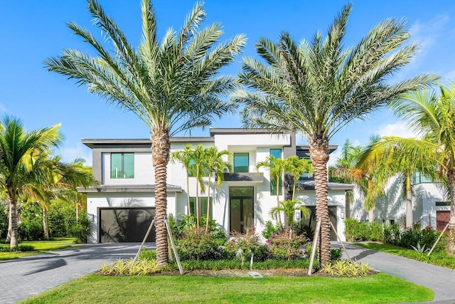 contemporary house featuring aphalt driveway, an attached garage, and stucco siding