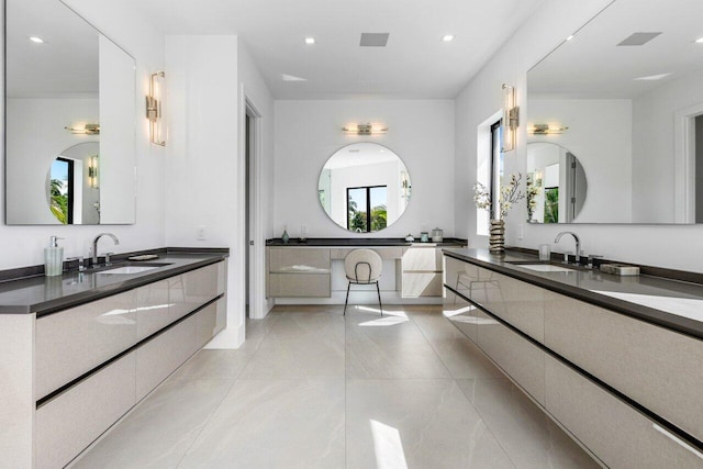 full bath featuring two vanities, a sink, and recessed lighting