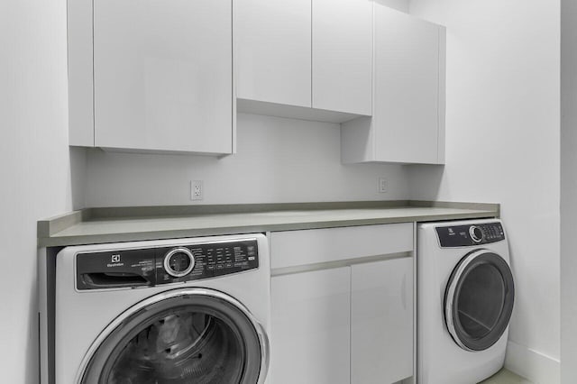 clothes washing area with cabinet space and washer / clothes dryer